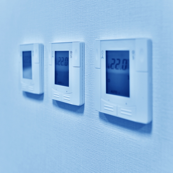 Three Thermostats on White Wall